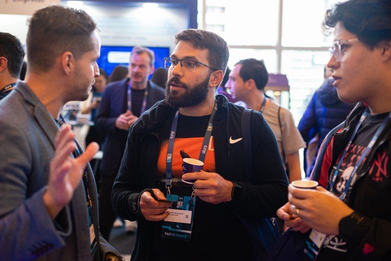 Participantes conversando no espaço dos stands no Dev Leaders Conference.