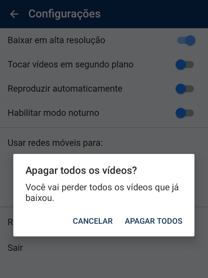 “Tela recortada de um aplicativo aberto nas configurações, no centro, um retângulo branco que não ocupa a tela inteira e o fundo fora desse retângulo está escurecido, o retângulo possui um título acima escrito “Apagar todos os vídeos?”, uma descrição:”você vai perder todos os vídeos que já baixou” e depois botões no canto inferior direito do retângulo com as opções: “cancelar” e “apagar todos”.”