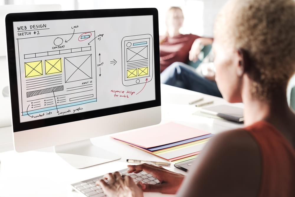 UI designer trabalhando em frente ao computador projetando interfaces.