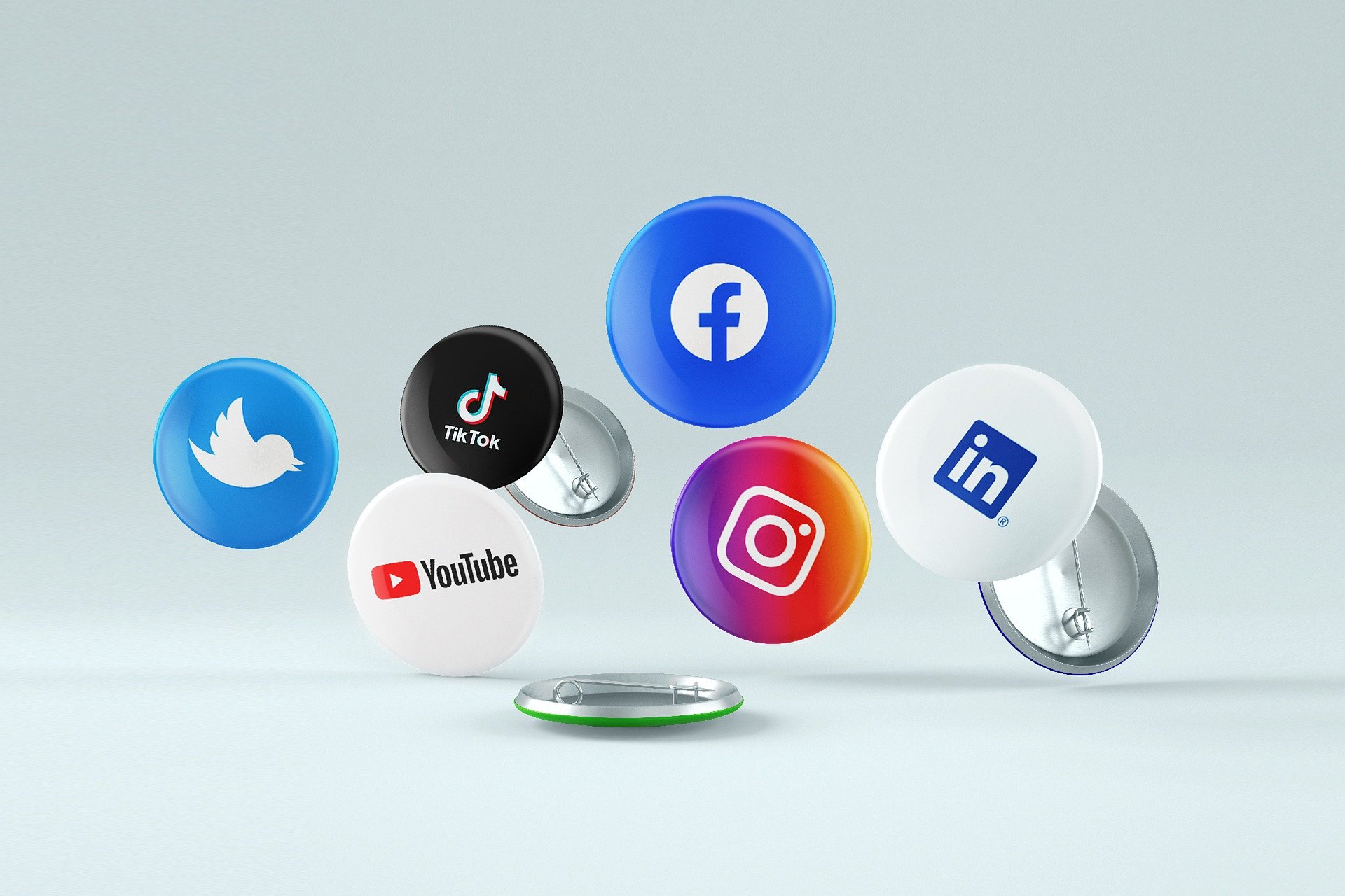 Broches com o facebook, instagram, twitter, tiktok e linkedin estampado em cada um.